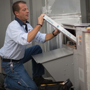 Anderson Air Corps employee fixing HVAC unit