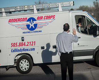 Anderson Air Corps employees in a van passing by waving man