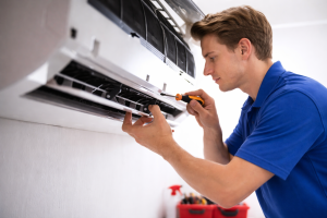 Technician performing maintenance on outdoor AC unit