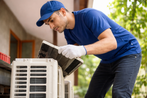 Technician cleaning air conditioning unit during service visit