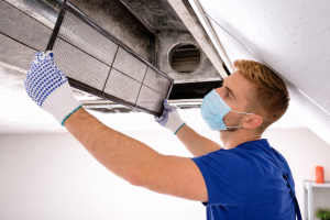 Technician removing dirty air filter from HVAC system