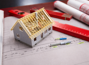 Miniature house model on blueprint for HVAC system planning